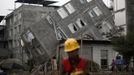 A rescuer walks in front of a damaged building after Saturday's earthquake in Lingguan town of Baoxing county, Sichuan province April 22, 2013. Rescuers struggled to reach a remote, rural corner of southwestern China on Sunday as the toll of the dead and missing from the country's worst earthquake in three years climbed to 208 with almost 1,000 serious injuries. The 6.6 magnitude quake struck in Lushan county, near the city of Ya'an in the southwestern province of Sichuan, close to where a devastating 7.9 quake hit in May 2008, killing 70,000. REUTERS/Aly Song (CHINA - Tags: DISASTER ENVIRONMENT TPX IMAGES OF THE DAY) Published: Dub. 22, 2013, 7:59 dop.