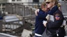 People embrace after looking through the wreckage of homes devastated by fire and the affects of Hurricane Sandy in the Breezy Point section of the Queens borough of New York October 31, 2012. The U.S. Northeast began an arduous slog back to normal on Wednesday after historic monster storm Sandy crippled transportation, knocked out power for millions and killed at least 64 people with a massive storm surge that caused epic flooding. REUTERS/Shannon Stapleton (UNITED STATES - Tags: ENVIRONMENT DISASTER) Published: Říj. 31, 2012, 8:32 odp.