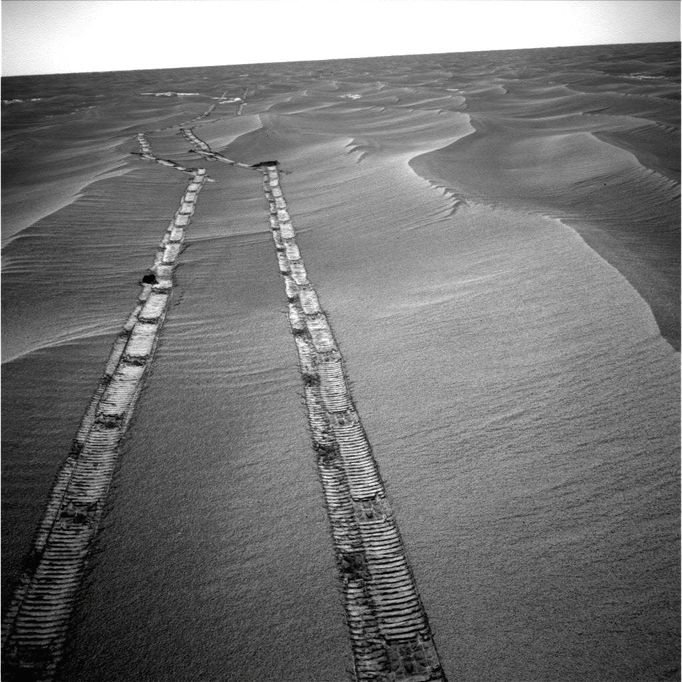 NASA's Mars Exploration Rover Opportunity used its navigation camera for this northward view of tracks the rover left on a drive from one energy-favorable position on the northern end of a sand ripple to another. The rover team calls this strategy hopping from lily pad to lily pad. Opportunity took this image on the 2,235th Martian day, or sol, of the rover's mission on Mars (May 8, 2010). The tracks are from a 14.87-meter (49-foot) drive southward on the preceding sol. Mars' southern hemisphere was in the minimal sunshine period close to the winter solstice, which occurred May 13, 2010 (Universal Time). Making progress on Opportunity's long trek to Endeavour Crater remains the extended mission's priority, but the amount of solar energy is so limited at this season that Opportunity needs to rest to recharge batteries for sols between drives. The sun crosses the sky low in the north. Choosing end points for drives that give a favorable northward tilt for the rover's solar panels makes the recharging go faster. The sand ripples in this part of Meridiani Planum are aligned generally north-south, so this means ending drives on the northern ends of the ripples. Opportunity took this image from the northern end of a ripple that is not visible in the image. For scale, the distance between the parallel wheel tracks is about 1 meter (3 feet). Image Credit: NASA/JPL-Caltech