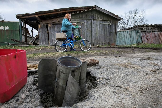 Místní obyvatelka vesnice Kukarhari prochází kolem nevybuchlého raketometu. Leží jen v pár krocích.