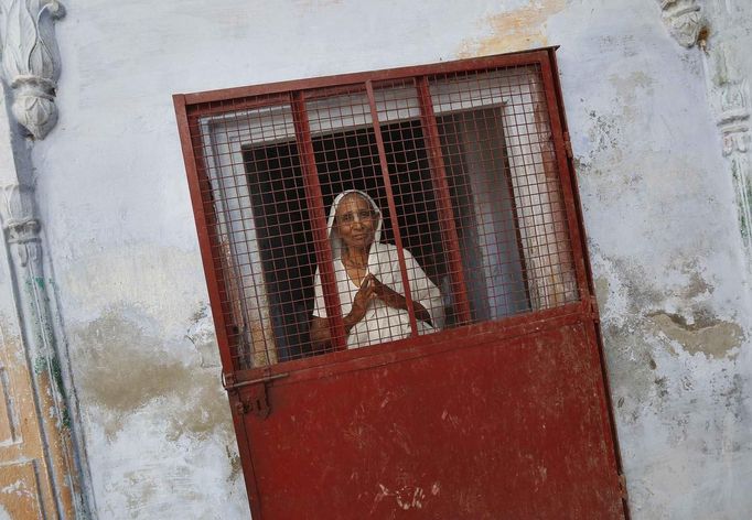 A widow poses at the entrance of a staircase at the Meera Sahavagini ashram in the pilgrimage town of Vrindavan in the northern Indian state of Uttar Pradesh March 6, 2013. Hundreds of widows who have been abandoned by their families live in the shelter, or ashram, run by the NGO Sulabh International. In India, when a man dies, traditionally his widow is expected to renounce all earthly pleasures, such as wearing colourful clothes or looking attractive, and she can face severe social discrimination. Sulabh International works to provide abandoned widows with education, healthcare and vocational skills. Issues surrounding the treatment of women are receiving special attention on March 8, which marks International Women's Day. Picture taken March 6, 2013. REUTERS/Adnan Abidi (INDIA - Tags: SOCIETY RELIGION EDUCATION) ATTENTION EDITORS: PICTURE 14 OF 24 FOR PACKAGE 'THE CITY OF WIDOWS'. SEARCH 'WIDOWS ABIDI' FOR ALL IMAGES Published: Bře. 8, 2013, 7:04 dop.