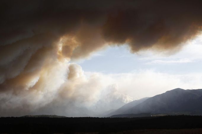 Smoke from the Waldo Canyon fire hovers over the U.S. Air Force Academy west of Colorado Springs in Colorado June 26, 2012. A monster Colorado wildfire raging near some of the most visited tourist areas in the state took a turn for the worse on Tuesday as hot winds pushed flames north, prompting the evacuation of 7,000 more people, officials said. REUTERS/Rick Wilking (UNITED STATES - Tags: DISASTER ENVIRONMENT) Published: Čer. 27, 2012, 12:47 dop.