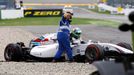 A track marshall gives a thumb up as Williams Formula One driver Felipe Massa of Brazil climbs out of the wreckage of his car after crashing in the first corner after the