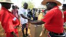 Kenyan comedians assist a man to cast his ballot during a mock-vote for the U.S. presidential elections in the ancestral home of U.S. President Barack Obama in Nyangoma Kogelo, 430 km (367 miles) west of Kenya's capital Nairobi, November 6, 2012. REUTERS/Thomas Mukoya (KENYA - Tags: SOCIETY ELECTIONS POLITICS) Published: Lis. 6, 2012, 9:54 dop.