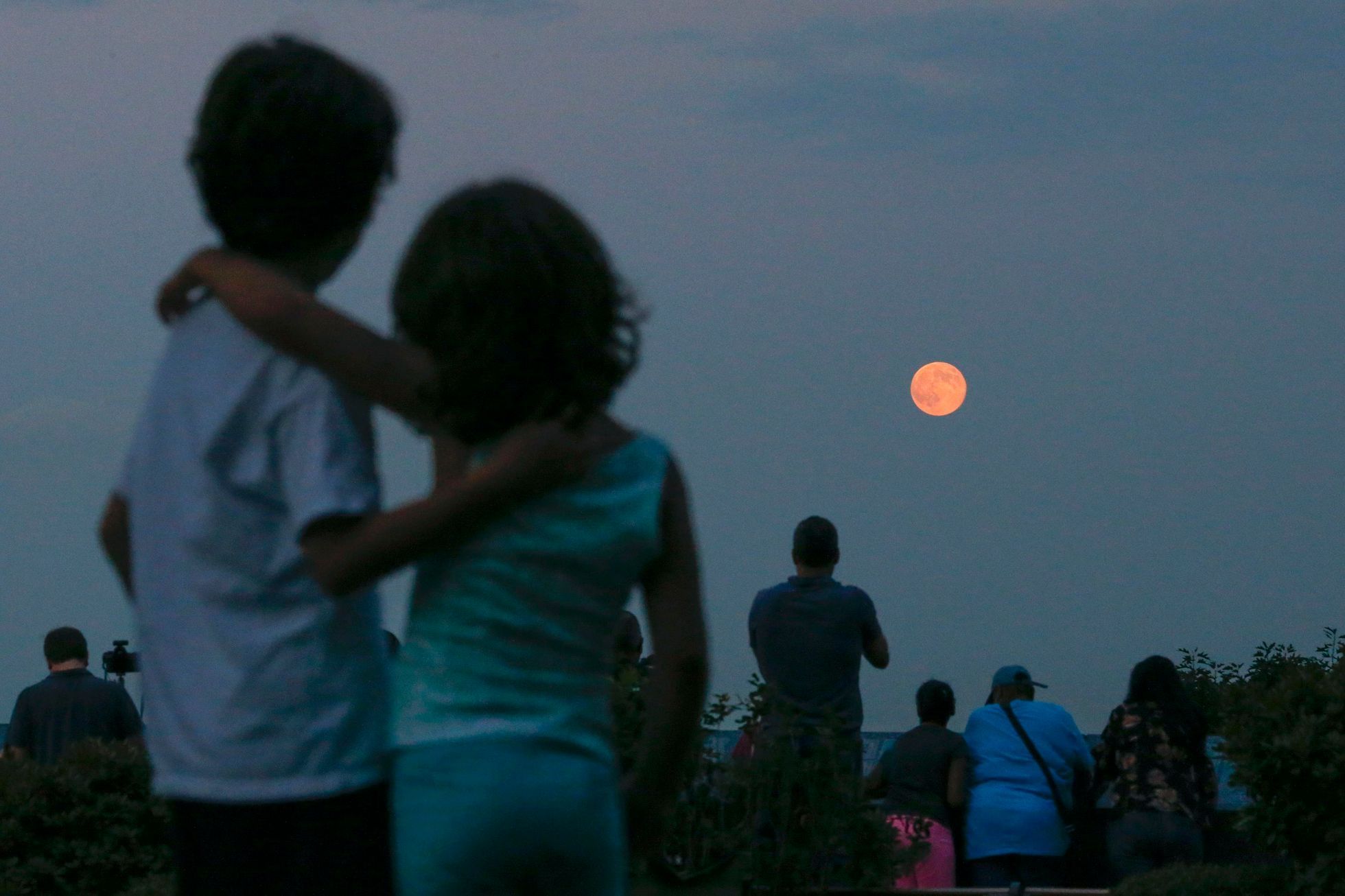 Children watch a full moon known as a &quot;supermoon&quot; while it rises over the skyline of New York and the Empire State Building, as seen from the Eagle Rock Reservation in West Orange, New Jerse