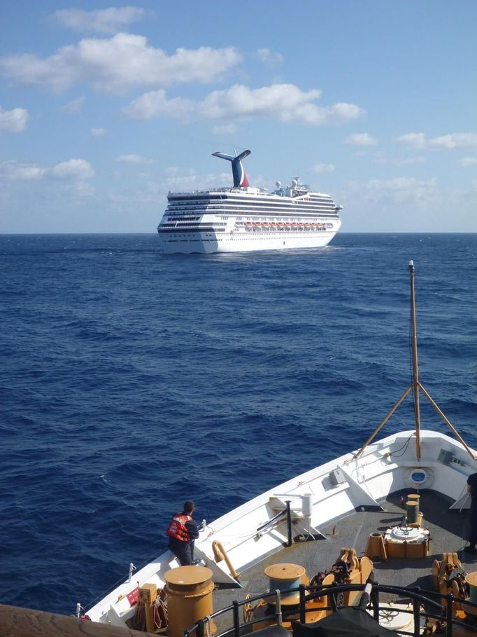 The U.S. Coast Guard Cutter Vigorous stands by to assist the cruise ship Carnival Triumph in the Gulf of Mexico, in this February 11, 2013 handout photo. The cruise ship lost propulsion after an engine room fire on February 10 and was adrift off southern Mexico's Yucatan peninsula. REUTERS/U.S. Coast Guard/Lt. Cmdr. Paul McConnell/Handout (GULF OF MEXICO - Tags: MILITARY SOCIETY MARITIME TRANSPORT TRAVEL) FOR EDITORIAL USE ONLY. NOT FOR SALE FOR MARKETING OR ADVERTISING CAMPAIGNS. THIS IMAGE HAS BEEN SUPPLIED BY A THIRD PARTY. IT IS DISTRIBUTED, EXACTLY AS RECEIVED BY REUTERS, AS A SERVICE TO CLIENTS Published: Úno. 11, 2013, 5:37 odp.