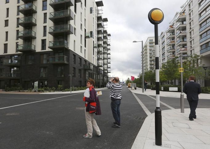 A member of the media photographs a new street in the Olympic Village built for the London 2012 Olympic Games in Stratford, east London on June 29, 2012. The village will accomodate up to 16,000 athletes and officials from more than 200 nations. Picture taken June 29, 2012. REUTERS/Olivia Harris (BRITAIN - Tags: SPORT OLYMPICS BUSINESS CONSTRUCTION CITYSPACE) Published: Čer. 30, 2012, 12:06 odp.