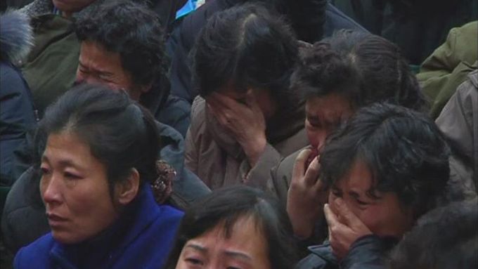 Zaměstnanci továrny v Pchjongjangu "truchlí" na oficiálním snímku severokorejské agentury KCNA.