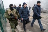 Na fotce eskortují separatisté ukrajinské zajatce k autobusům.