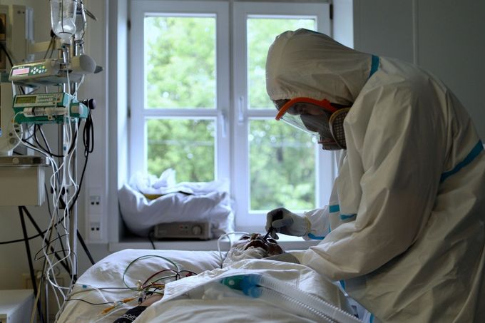 Zdravotník pečuje o pacienta nakaženého covidem-19 v moskevské nemocnici N.I. Pirogova (23.5.2020)
