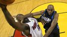 Shaquille O'Neal z Miami (vlevo) je pod košem faulovaný dallaským Jerry Stackhousem.