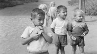 Děti stojí na prašné cestě, v pozadí jsou vidět paneláky (Bělehrad, Jugoslávie, 1959).