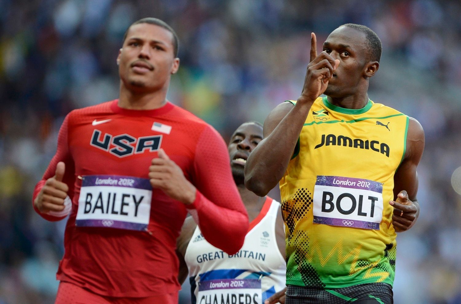 Jamajský sprinter Usain Bolt dobíhá před Američanem Ryanem Baileym během semifinále na 100 metrů na OH 2012 v Londýně.