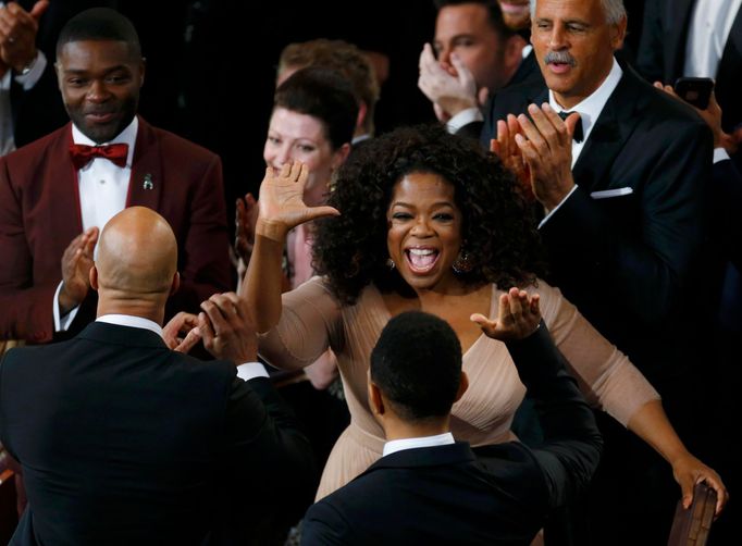 Ophra Winfrey congratulates John Legend and Common after &quot;Glory&quot; won the Oscar for best original song during the 87th Academy Awards in Hollywood