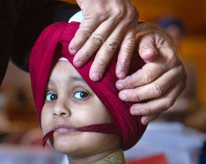 Čtyřletý Jujhtar Lehal čeká, až mu otec uváže správně turban. Je to dřina - jak samotné vázání, tak i to čekání.