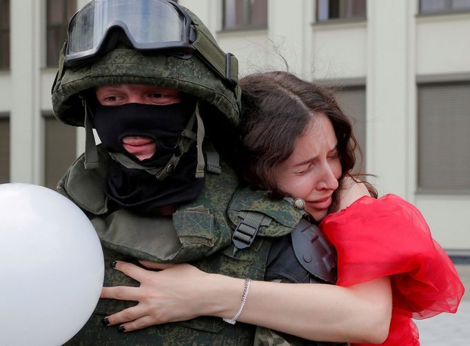 Tuto fotografii vybrala agentura Reuters mezi nejlepší snímky roku 2020. Demonstrantka 14. srpna objímá před budovou vlády v Minsku příslušníka speciálních jednotek.