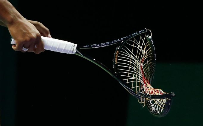 Serena Williams of the U.S. walks off the court with her broken racquet during her WTA Finals singles semi-final tennis match against Caroline Wozniacki of Denmark at the