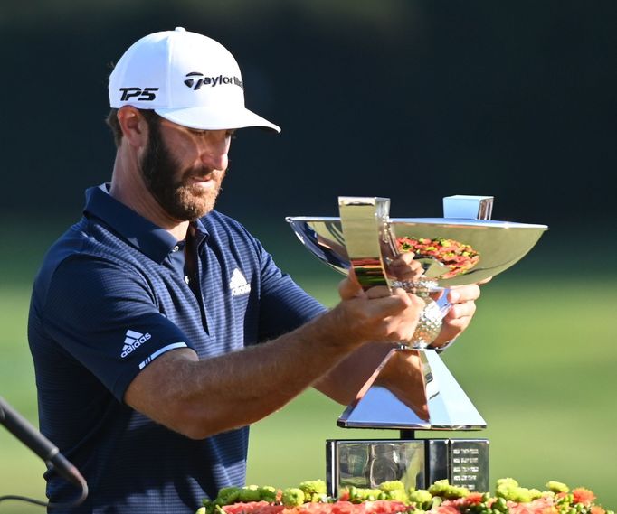 Sep 7, 2020; Atlanta, Georgia, USA; Dustin Johnson with the FedEx Cup trophy after the final round of the Tour Championship golf tournament at East Lake Golf Club. Mandat