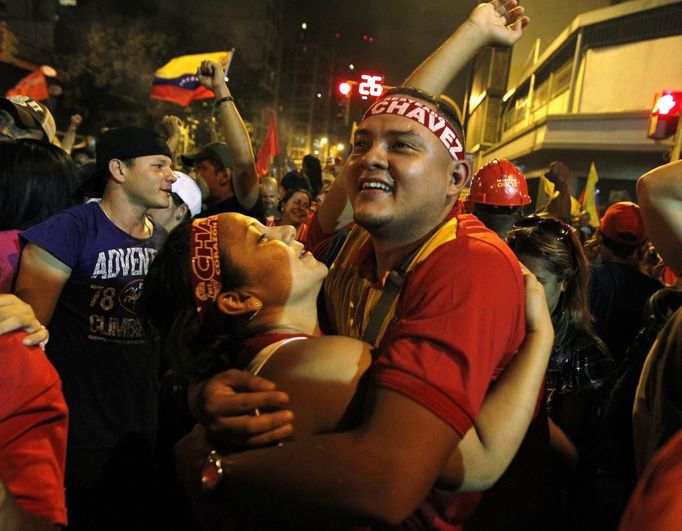 Supporters of Venezuelan President Hugo Chavez cheer as he appears on a balcony of Miraflores Palace in Caracas October 7, 2012. Venezuela's socialist President Chavez won re-election in Sunday's vote with 54 percent of the ballot to beat opposition challenger Henrique Capriles. REUTERS/Tomas Bravo (VENEZUELA - Tags: POLITICS ELECTIONS) Published: Říj. 8, 2012, 5:57 dop.