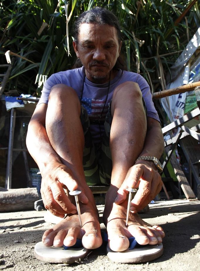 Ruben Enaje, 52, who will portray Jesus Christ for the 27th time, tests a three-inch nail on his feet which he will use on a Good Friday crucifixion re-enactment in San Pedro Cutud town, Pampanga province, north of Manila March 29, 2013. The Roman Catholic church frowns on the gory spectacle held in the Philippine village of Cutud every Good Friday but that does nothing to deter the faithful from emulating the suffering of Christ and taking a painful route to penitence. Holy Week is celebrated in many Christian traditions during the week before Easter. REUTERS/Romeo Ranoco (PHILIPPINES - Tags: POLITICS RELIGION SOCIETY) Published: Bře. 29, 2013, 12:54 dop.