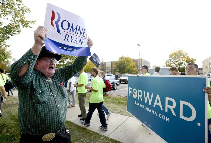 Lloyd Holman (L) holds up a sign to show support for Republican presidential candidate Mitt Romney as he stands in a crowd of U.S. President Barack Obama supporters before the first 2012 U.S. presidential debate at Denver University in Denver, Colorado October 3, 2012. REUTERS/Mark Leffingwell (UNITED STATES - Tags: POLITICS ELECTIONS USA PRESIDENTIAL ELECTION) Published: Říj. 4, 2012, 12:12 dop.