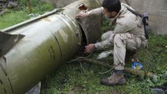 Příslušník povstaleckých jednotek kontroluje vypálenou raketu na jihozápadě Sýrie.