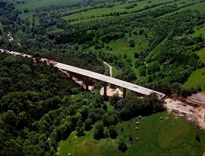 Nahoře 92. kilometr dálnice D8, dole údolí Rybného potoka.