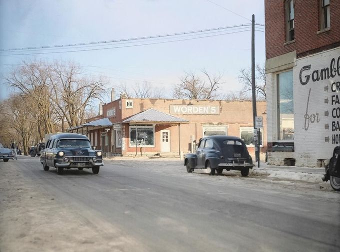 Pohřební průvod s tělem Bernice Wordenové projíždí hlavní ulicí Plainfieldu ve Wisconsinu 20. listopadu 1957 kolem železářství, kde byla zavražděna. Kolorováno