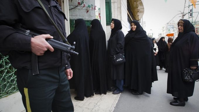 Policista hlídá před volební místností v mešitě na východě Teheránu