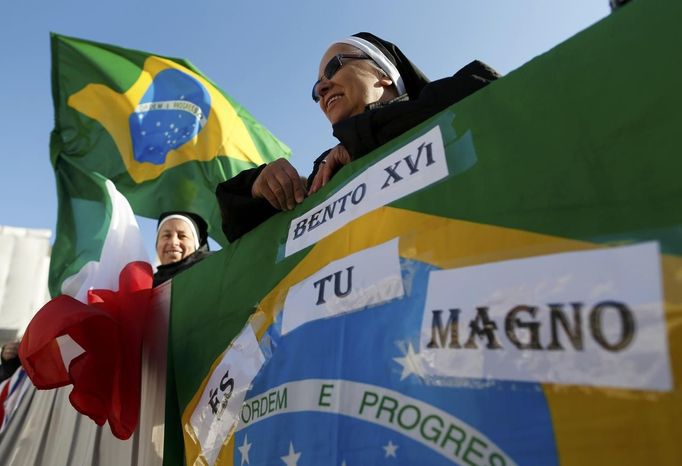 Nuns from Brazil wait for the arrival of Pope Benedict XVI to hold his last general audience at St Peter's Square at the Vatican February 27, 2013. The weekly event which would normally be held in a vast auditorium in winter, but has been moved outdoors to St. Peter's Square so more people can attend. The pope has two days left before he takes the historic step of becoming the first pontiff in some six centuries to step down instead of ruling for life. REUTERS/Alessandro Bianchi (VATICAN - Tags: RELIGION) Published: Úno. 27, 2013, 10:16 dop.