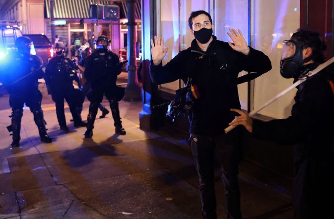 Demonstrant se vzdává před policií v Portlandu ve státě Oregon.