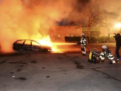 Loni hořely na předměstí Stockholmu desítky aut.