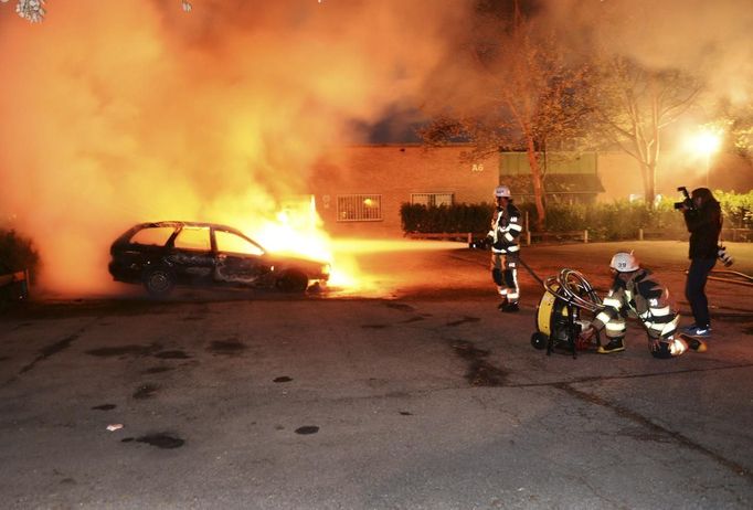 Na předměstí Stockholmu skončilo v plamenech několik desítek aut. Už třetí noc po sobě.