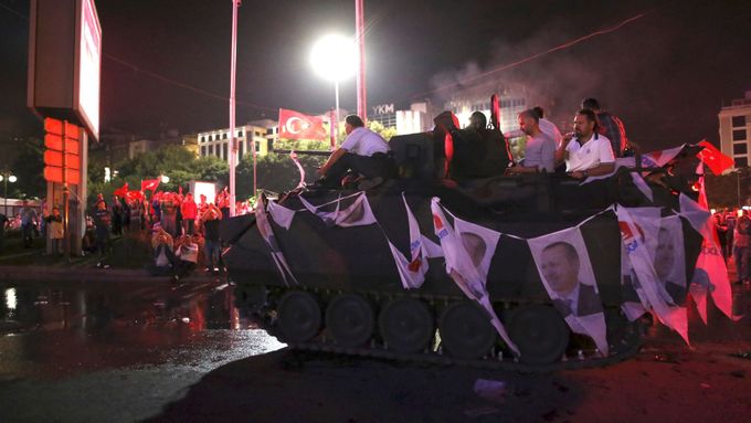 Příznivci prezidenta Recepa Tayyipa Erdogana sedí na tanku projíždějícím ulicemi Ankary.