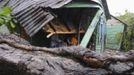 A family sits in their porch after winds from Tropical Storm Isaac brought a tree down, hitting the corner of their house, in El Habanero, Barahona province, August 25, 2012. Tropical Storm Isaac emerged over warm Caribbean waters on Saturday slightly weaker but ready to regroup after dumping torrential rains on the Dominican Republic and Haiti. REUTERS/Ricardo Rojas (DOMINICAN REPUBLIC - Tags: DISASTER ENVIRONMENT) Published: Srp. 25, 2012, 4:38 odp.