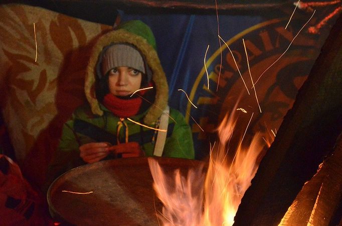 Lidé se celé noci ohřívají u sudů, pospávají a hlídají.