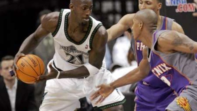 Kevin Garnett z Minnesoty Timberwolves (vlevo) naznačuje v zápase NBA únik obráncům Phoenixu Suns, Raja Bellovi (vpředu) a Shawnu Marionovi.