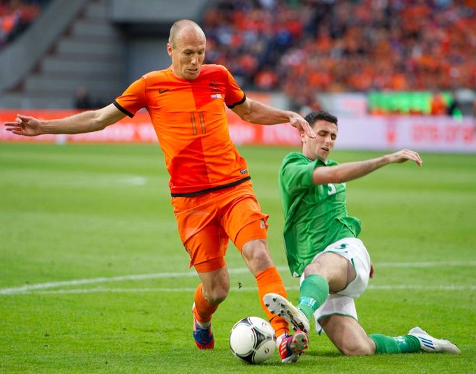 Holandský fotbalista Arjen Robben se s míčem vyhýbá Oliveru Norwoodovi ze Severního Irska v přípravném utkání na Euro 2012.