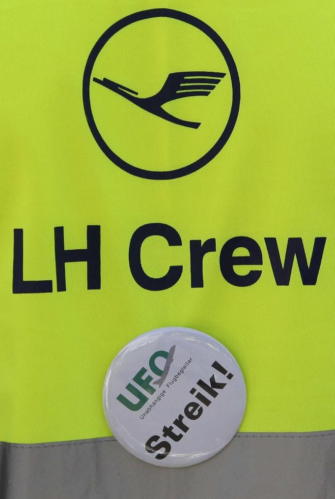 A member of German air carrier Lufthansa cabin crew union "UFO" wears a vest as he attends a wage strike at the Berlin Tegel airport, September 4, 2012. Lufthansa passengers face widespread flight disruption after cabin crew representatives said they continue a series of strikes over pay and cost-cutting measures at Germany's largest airline. The UFO union, which represents around two-thirds of Lufthansa's 19,000 cabin crew, late on Thursday called on its members to strike from 0400 GMT to 1500 GMT on Tuesday in Frankfurt and Berlin's Tegel airport from 0300-1100 GMT. REUTERS/Tobias Schwarz (GERMANY - Tags: TRANSPORT BUSINESS EMPLOYMENT CIVIL UNREST) Published: Zář. 4, 2012, 8:32 dop.