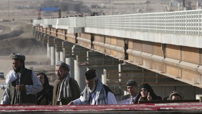 Afghánci procházejí kolem nového mostu v Ser Chán Bandaru na afghánské straně