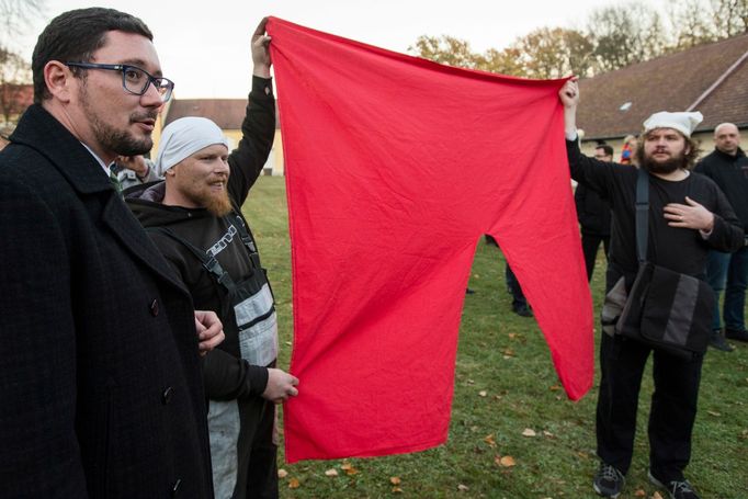 Tiskový mluvčí Jiří Ovčáček přihlíží demonstraci odpůrců Miluše Zemana, kteří drží symbol Červených trenek, jenž do povědomí veřejnosti dostala skupina Ztohoven. 2015