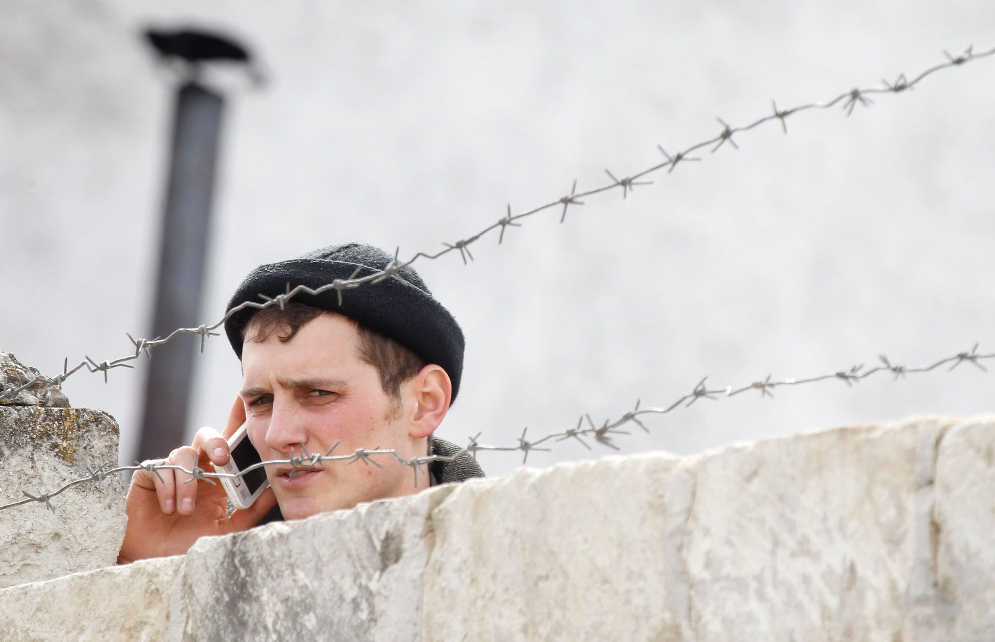 A Ukrainian serviceman talks on the phone at a Ukrainian military base in the village of Perevalnoye, outside Simferopol