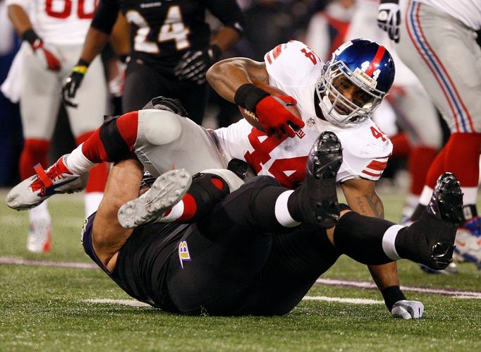 Ahmad Bradshaw (44) z New York Giants si "ustlal" na hráči Baltimore Ravens Haloti Ngatovi.