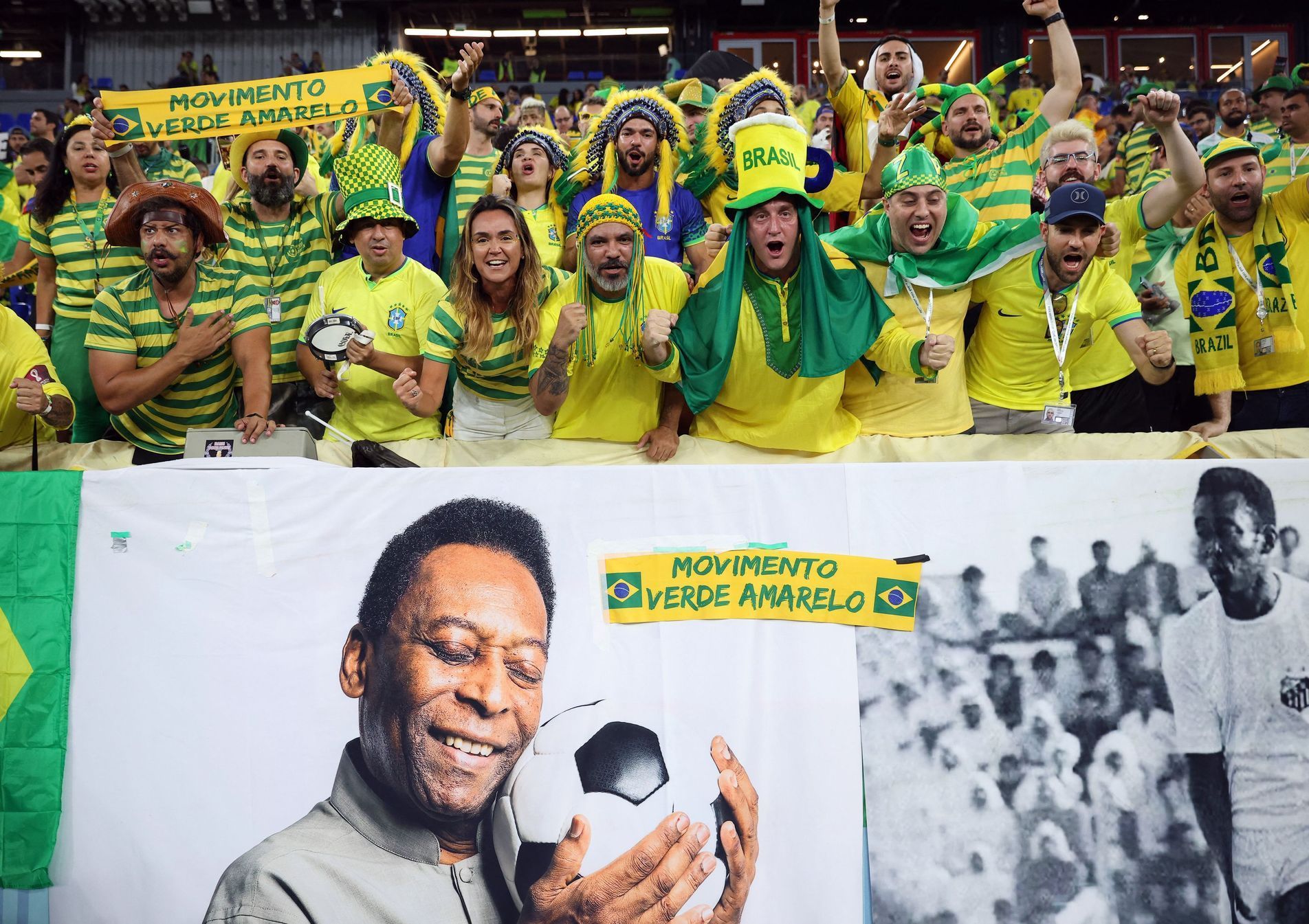 Brazilští fanoušci s transparentem se snímky Pelého před osmifinále MS 2022 Brazílie - Jižní Korea