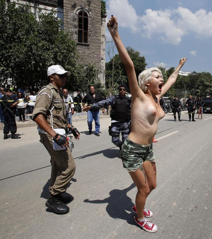 An activist from Femen Brazil protests in support of the native Indian community in front of the Brazilian Indian Museum in Rio de Janeiro, March 22, 2013. Brazilian military police took position early morning outside the abandoned Indian museum, where a native Indian community of around 30 individuals have been living since 2006. The Indians were summoned to leave the museum in 72 hours by court officials since last week, local media reported. The group is fighting against the destruction of the museum, which is next to the Maracana Stadium. REUTERS/Sergio Moraes (BRAZIL - Tags: CIVIL UNREST POLITICS SOCIETY SPORT) TEMPLATE OUT Published: Bře. 22, 2013, 5:25 odp.