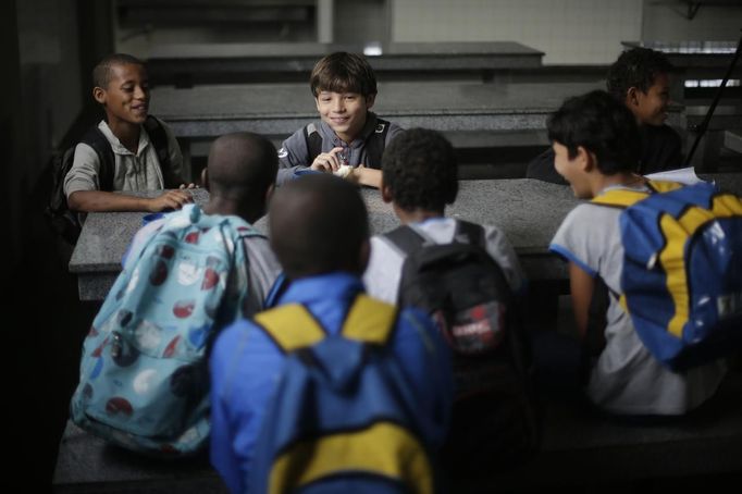 Gabriel Muniz, 11, talks with schoolmates in Campos dos Goytacazes, 274 kilometres (170 miles) northeast of Rio de Janeiro August 23, 2012. Despite being born with malformation of his feet, fourth grader Gabriel puts in hours into soccer everyday in his neighbourhood. He aspires to be a professional soccer player just like his idol Argentina's Lionel Messi of Barcelona FC. REUTERS/Ricardo Moraes (BRAZIL - Tags: SPORT SOCCER SOCIETY HEALTH EDUCATION) Published: Srp. 24, 2012, 2:25 dop.