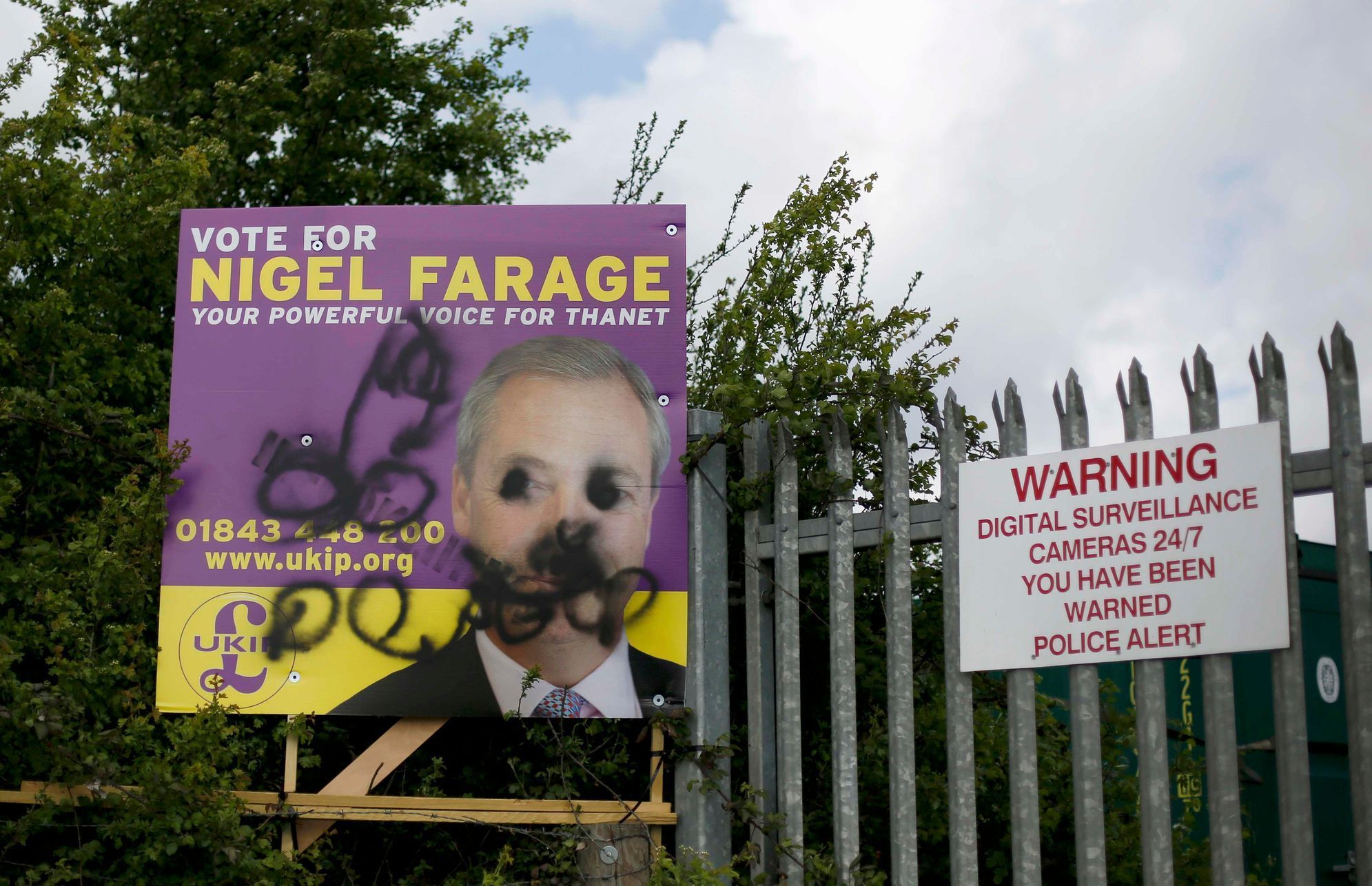 Pomalovaný plakát šéfa Strany nezávislosti Velké Británie (UKIP) Nigela Farage.
