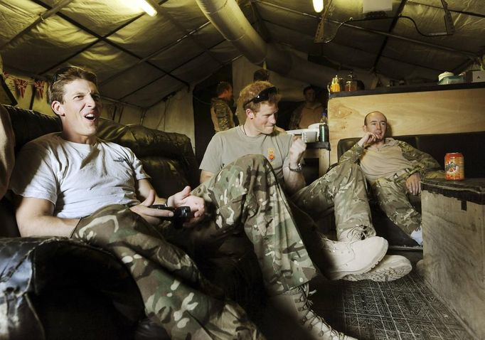 Britain's Prince Harry (C) plays a computer soccer game with fellow Apache pilot Captain Simon Beattie (L) at Camp Bastion, southern Afghanistan in this photograph taken November 3, 2012, and released January 21, 2013. The Prince, who is serving as a pilot/gunner with 662 Squadron Army Air Corps, is on a posting to Afghanistan that runs from September 2012 to January 2013. Photograph taken November 3, 2012. REUTERS/John Stillwell/Pool (AFGHANISTAN - Tags: MILITARY POLITICS SOCIETY MEDIA ROYALS CONFLICT) Published: Led. 21, 2013, 8:02 odp.