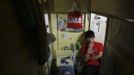 King, 18, who works as a bartender smokes his cigarette in a wooden box he uses as living space in Hong Kong October 9, 2012. In Hong Kong's middle-class residential area, short distance from its shopping and financial districts, 24 people live in these wooden boxes, or "coffin homes", packed in a single apartment of little over 50 square meters. Its residents pay 1450 Hong Kong dollars ($180) for their living space built of wooden panels of 2 meters by 70 cm. To maximize income from the rent in central Hong Kong landlords build "coffin homes", nicknamed due to their resemblance to real coffins. Space has always been at a premium in Hong Kong where developers plant high-rises on every available inch. REUTERS/Damir Sagolj (CHINA - Tags: SOCIETY REAL ESTATE BUSINESS) Published: Říj. 9, 2012, 1:45 odp.