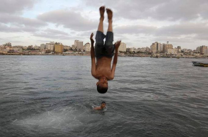 Palestinský chlapec skáče do vody na březích největšího města v pásmu Gazy - v Gaze.